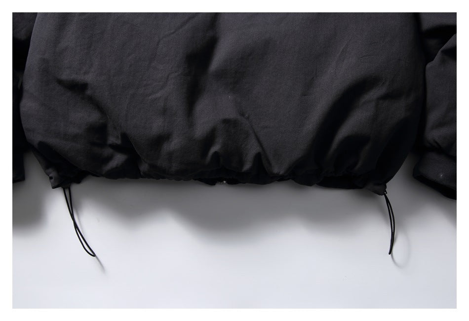 Close-up of the black jacket's gathered hem with adjustable drawcords.