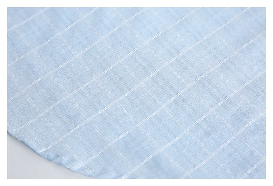 Pale blue fabric detail showing a raised white grid pattern and a curved hem.