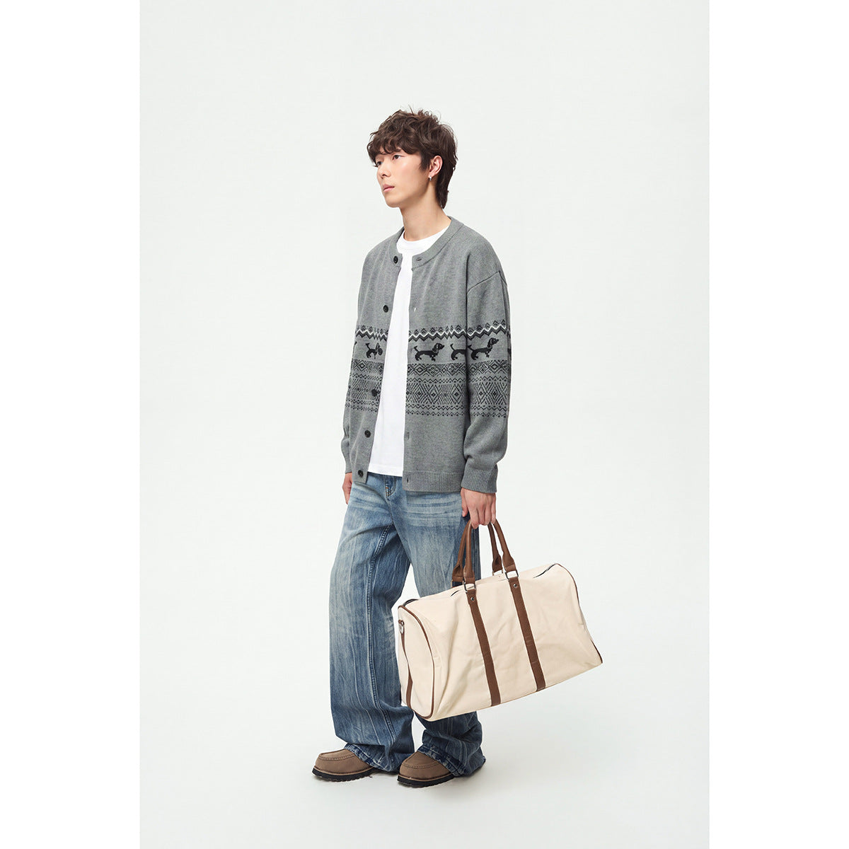 Model wearing a gray button-front cardigan with black dog motifs and geometric bands, paired with jeans.
