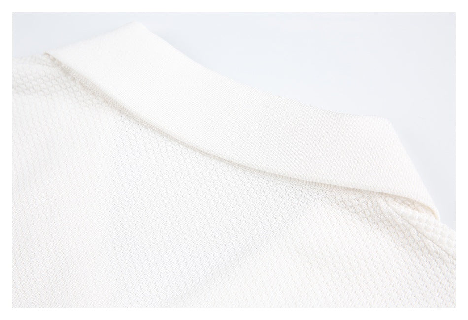 Close-up of a white knit garment collar and textured fabric.