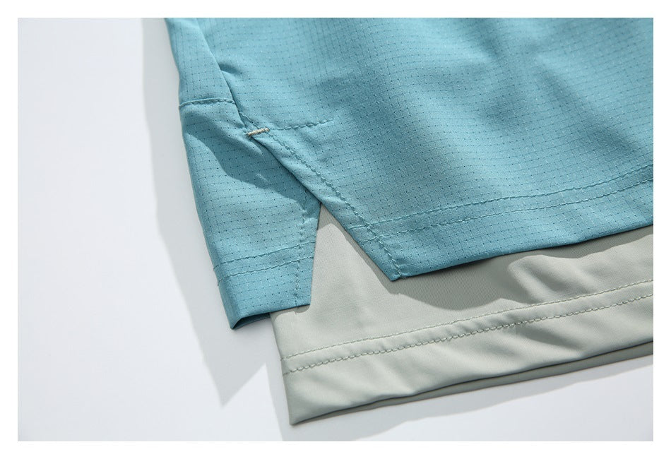 Close-up of aqua shorts with a side hem slit over pale gray inner shorts.