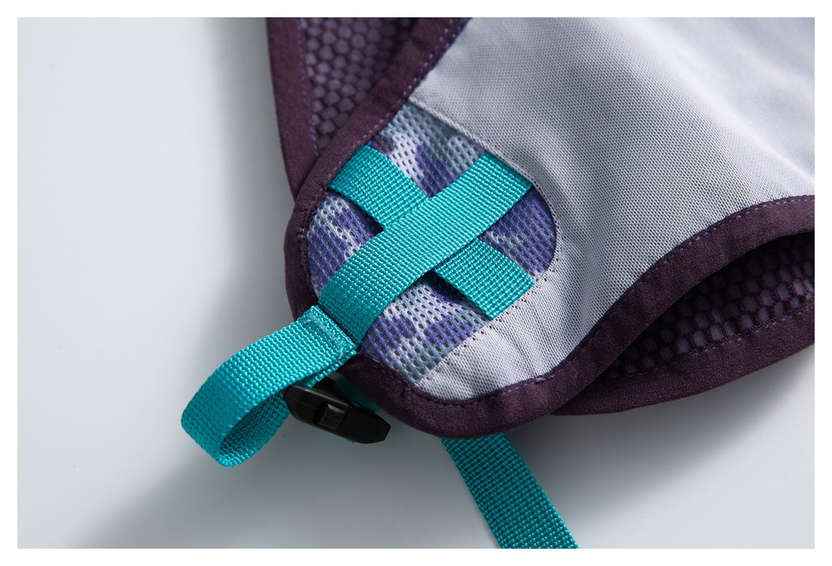 Close-up of turquoise webbing crossing a gray and purple backpack panel beside a black buckle.