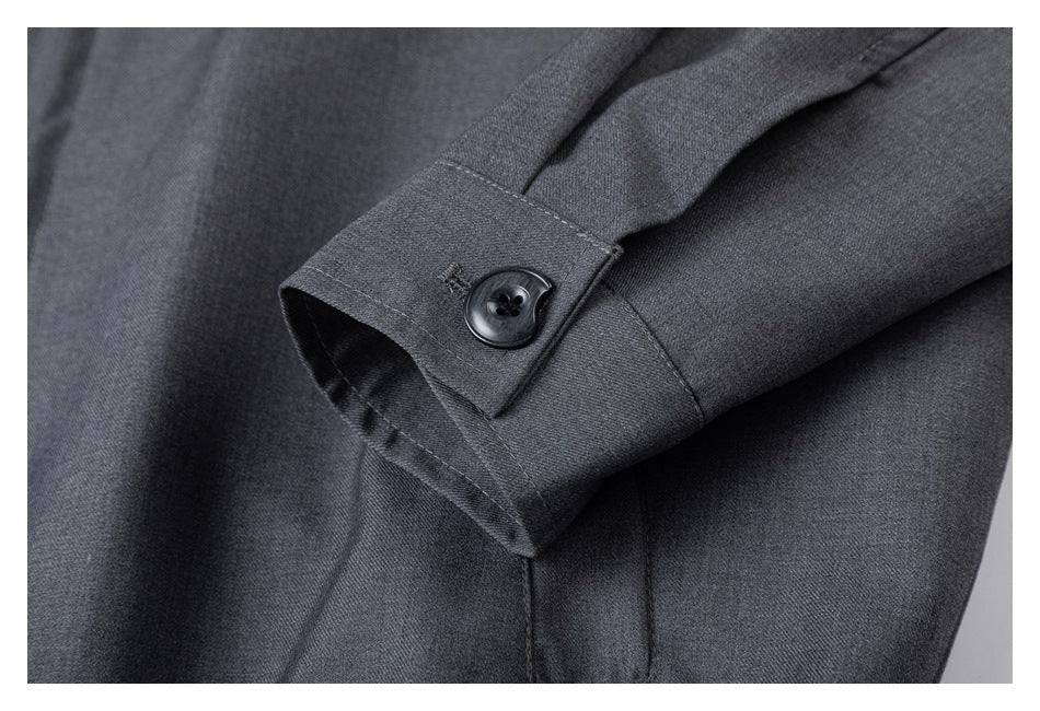 Close-up of a charcoal gray sleeve cuff with a dark button and stitched seams.