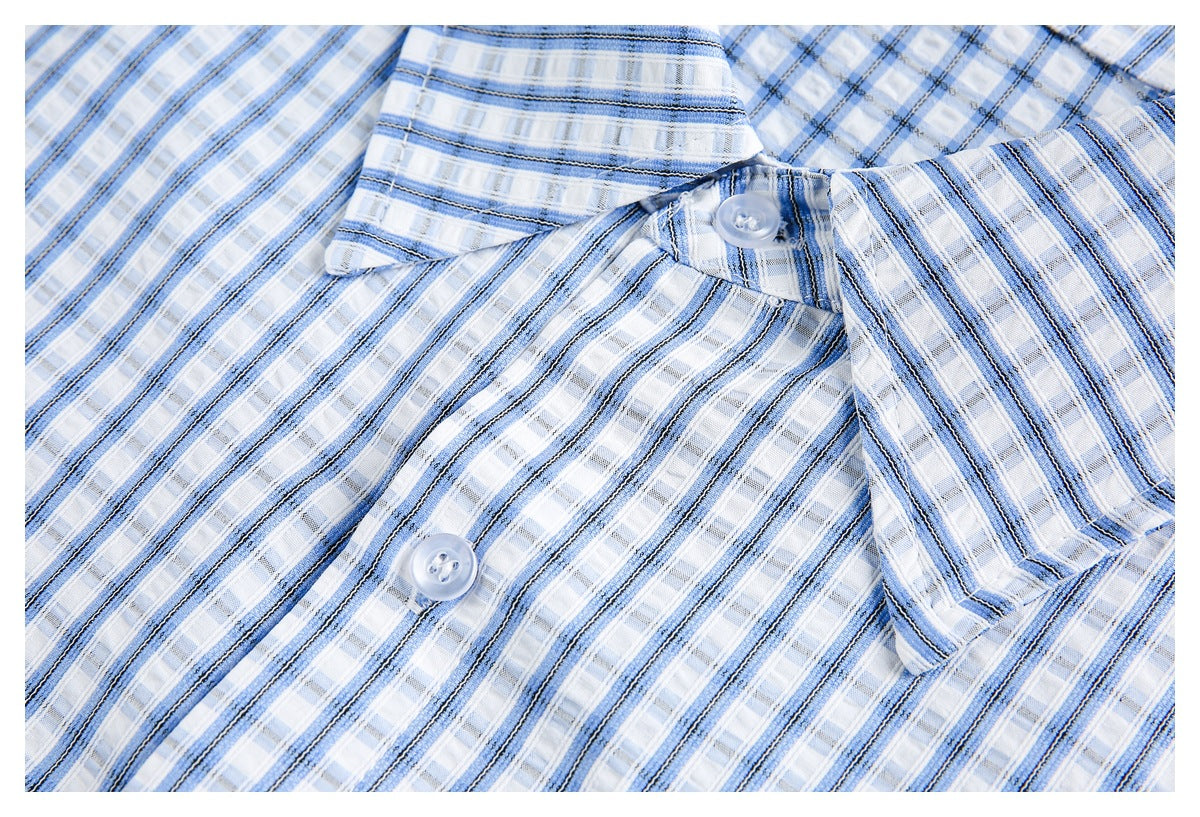 Close-up of a blue plaid shirt collar and button placket with translucent buttons.