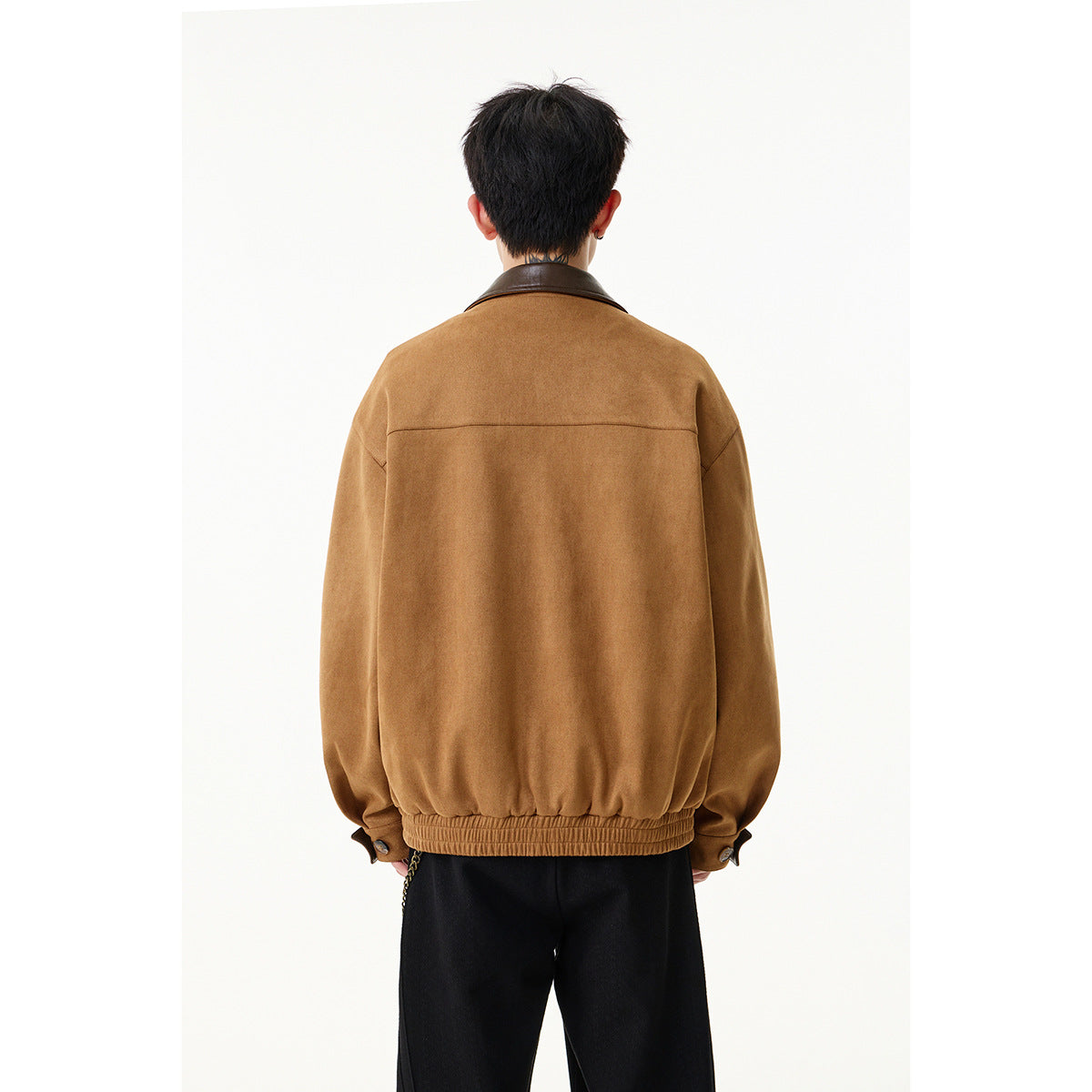 Back view of a model wearing a camel-brown jacket with a dark brown collar and gathered elastic hem.