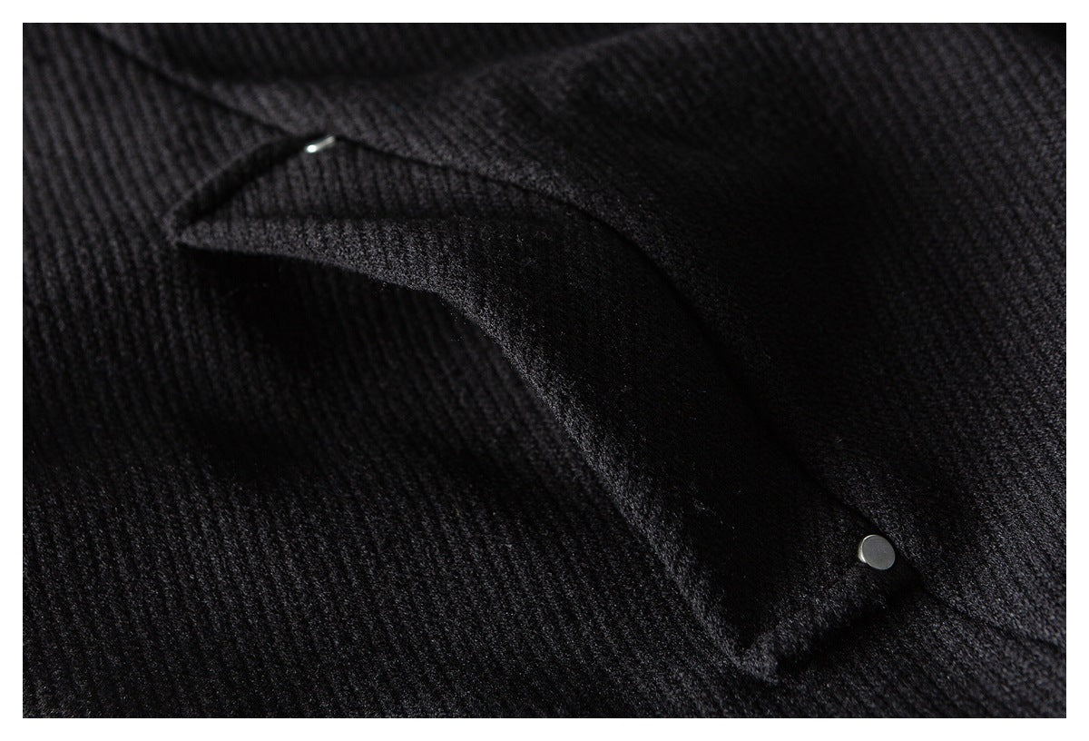 Close-up of a black flap pocket secured with a small silver snap.