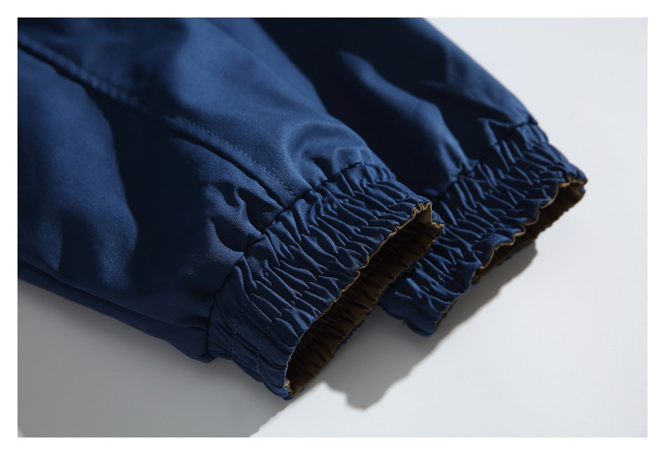 Close-up of gathered elastic cuffs on the sleeves of a navy jacket.