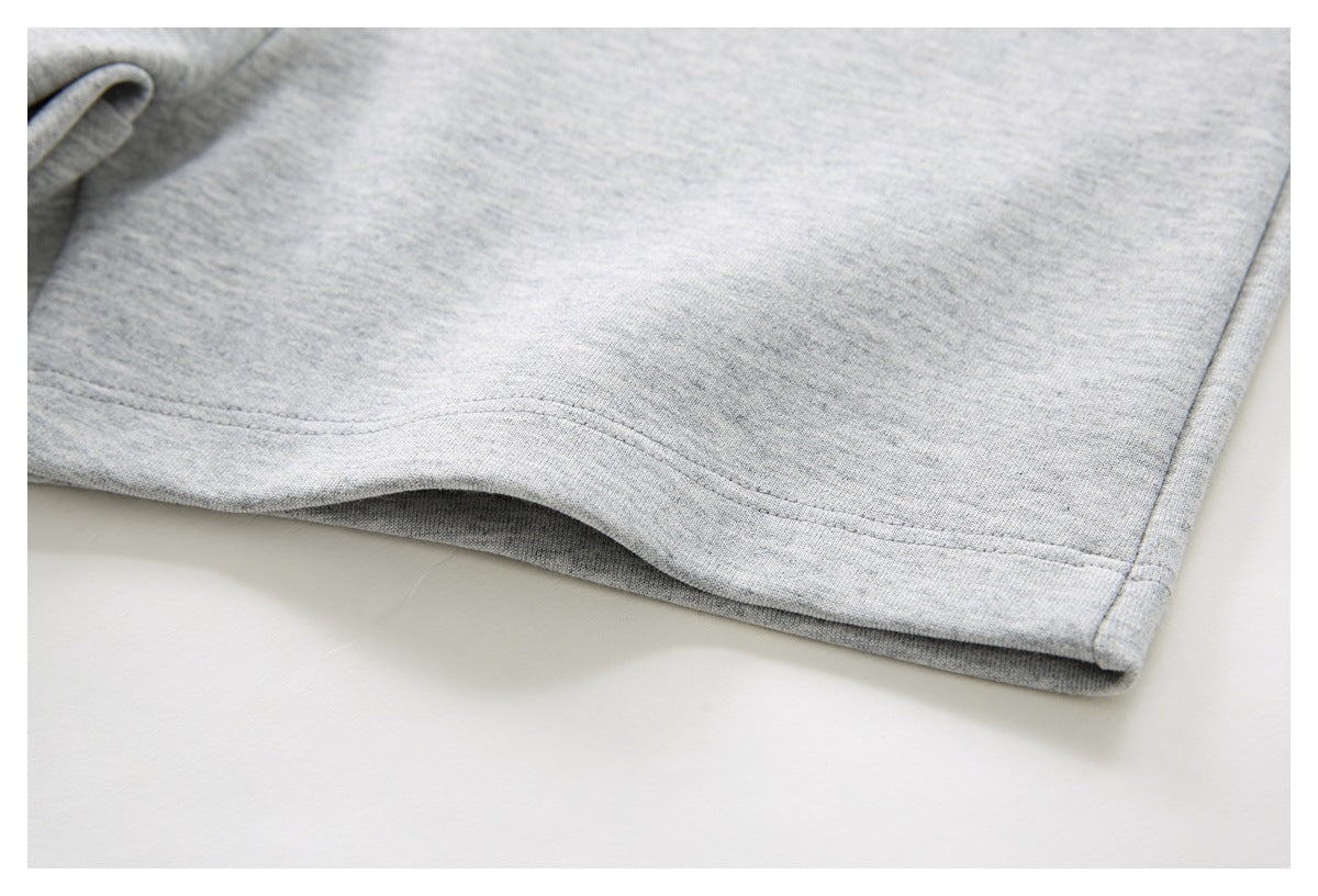 Close-up of the gray shorts’ hem, showing double stitching and the side seam.
