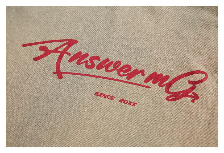 Close-up of red script lettering and small text printed on beige garment fabric.