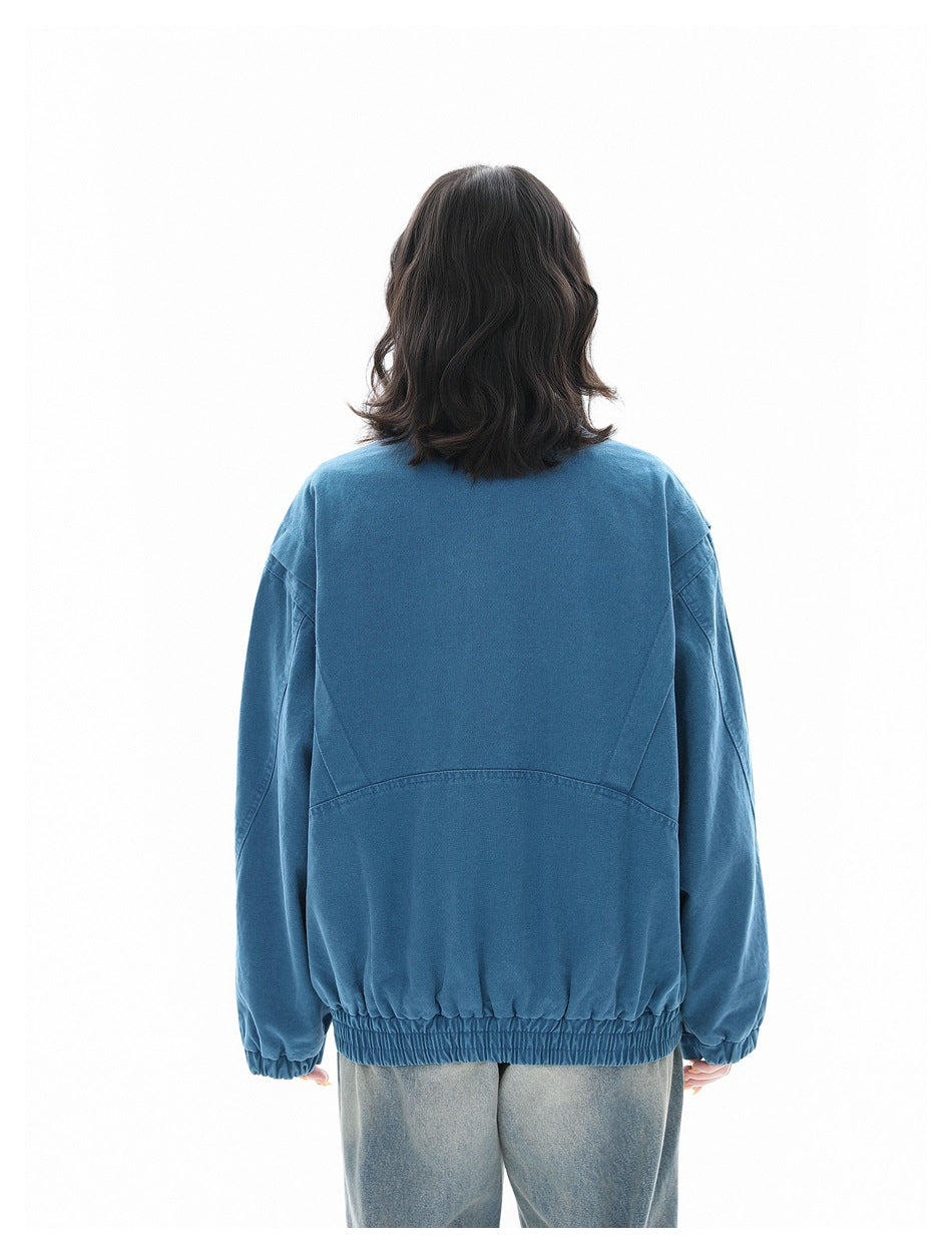 Back view of a model wearing a blue oversized jacket with seam details and an elasticated hem.