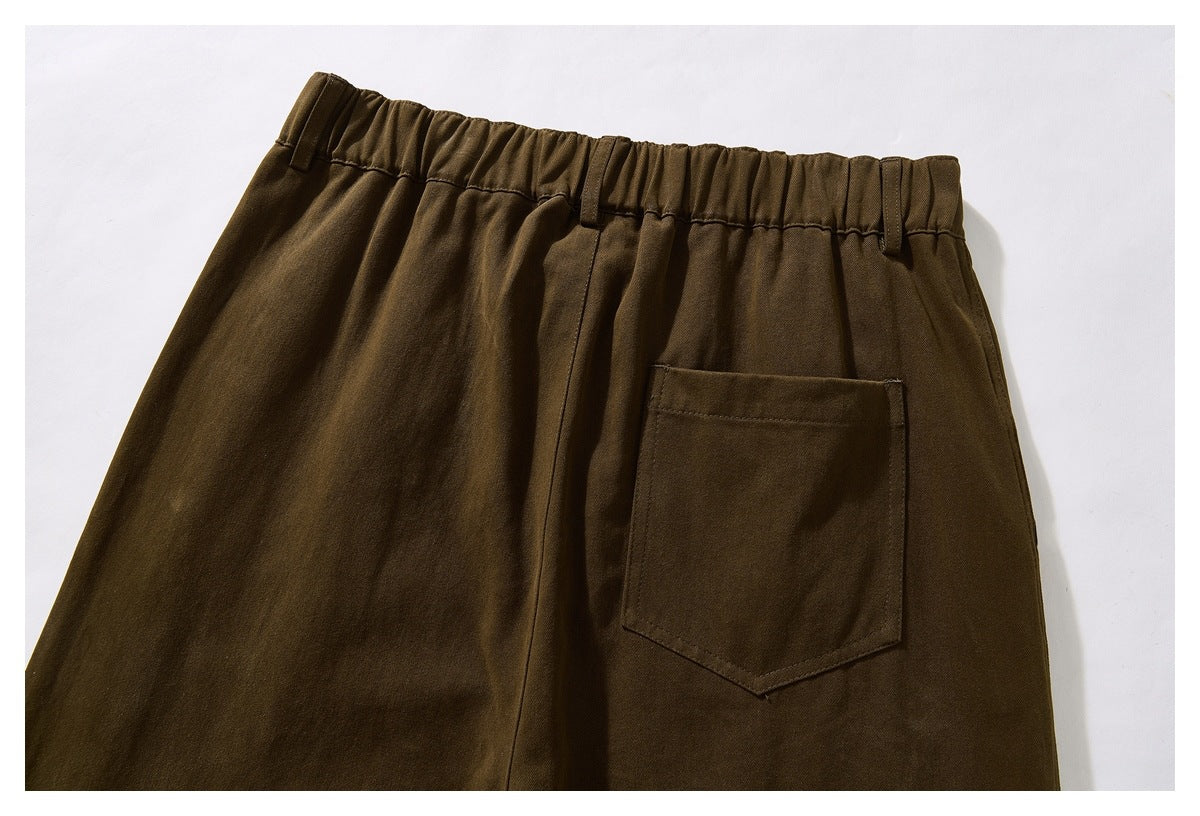 Partial rear view of olive-brown trousers with a gathered waistband, belt loops, and a patch pocket.