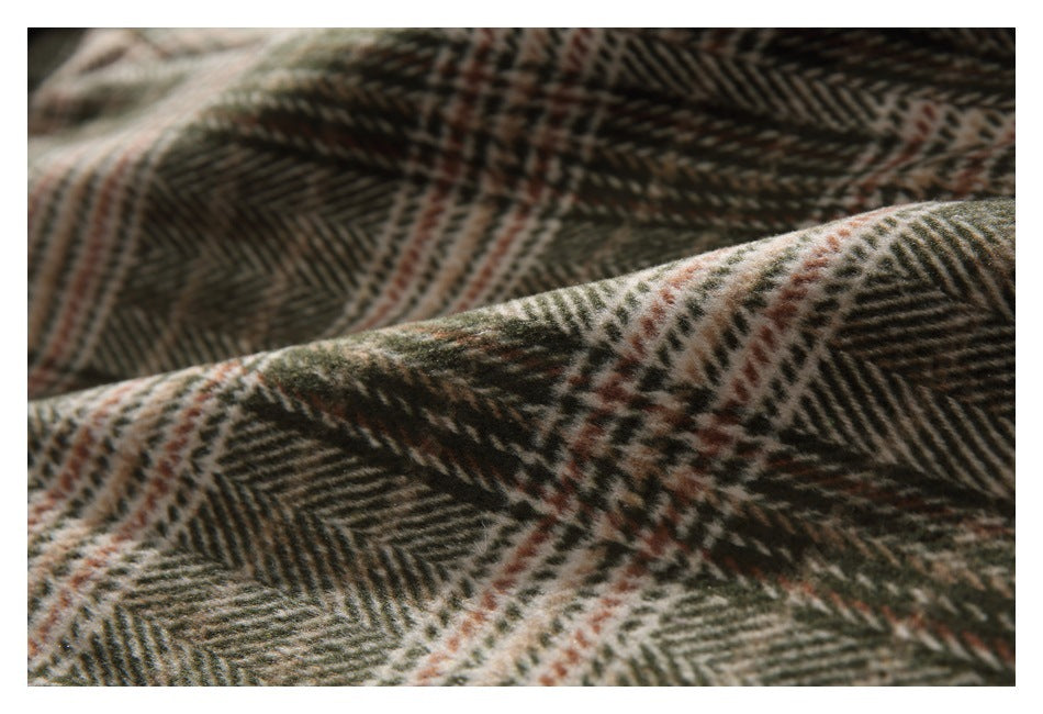 Macro view of brown, olive, and cream herringbone plaid fabric in soft folds.