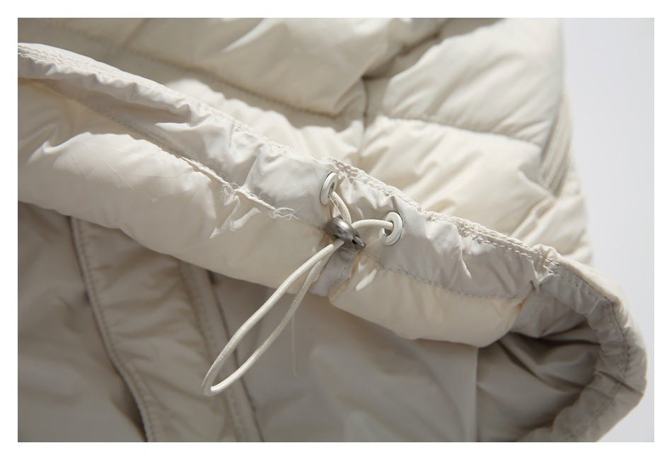 Close-up of an ivory jacket's hood drawcord, eyelets and toggle.
