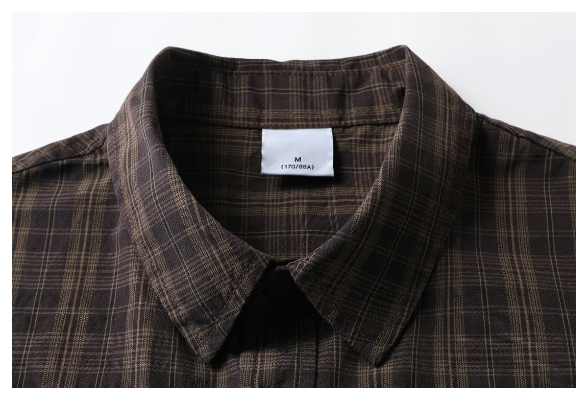 Close-up of a dark brown plaid shirt collar with a white M size label.