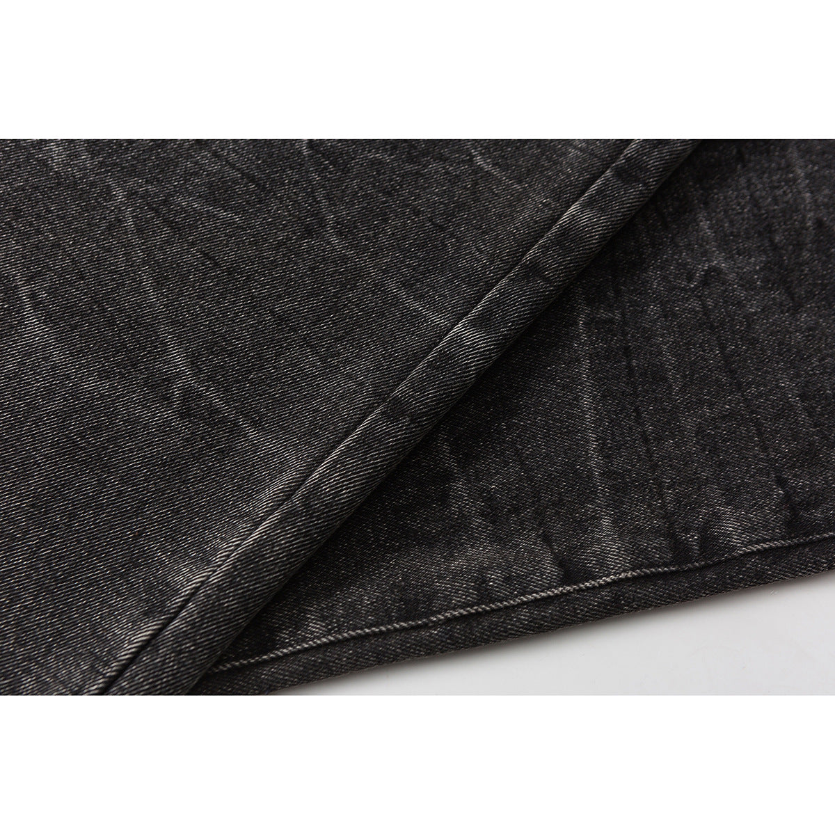 Close-up of a folded hem showing the dark washed denim texture and stitching.