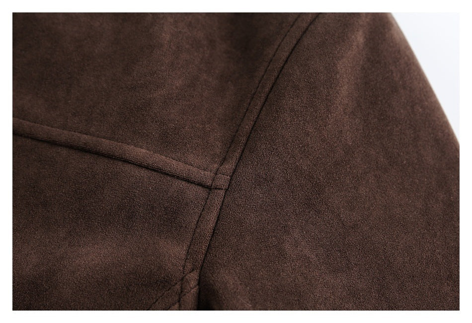 Close-up of dark brown coat fabric with intersecting stitched seams.