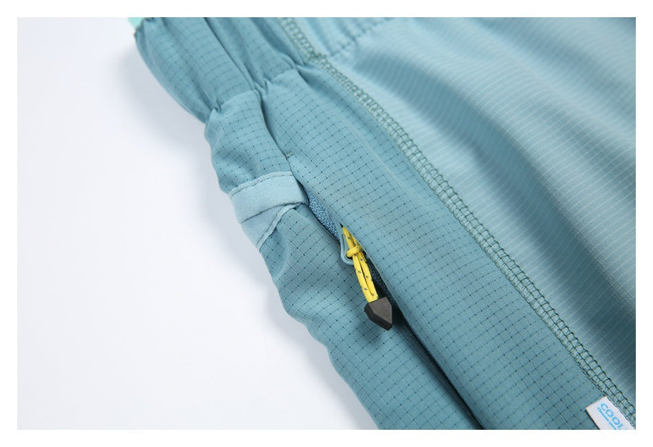 Close-up of a yellow zipper pull on a blue shorts pocket, with visible stitching and a small garment label.