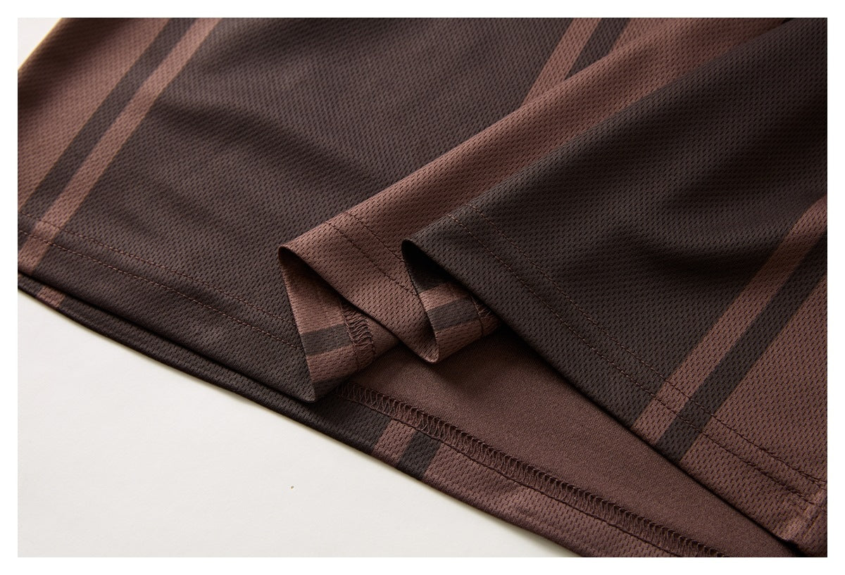 Close-up of the brown striped polo's folded hem and stitched seam.