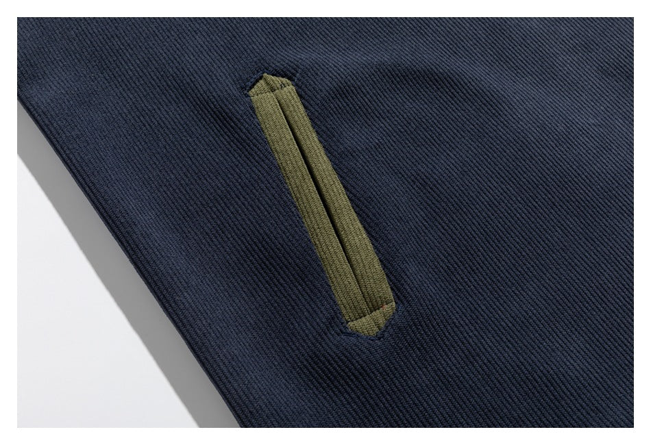 Close-up of a narrow olive fabric detail on navy textured jacket fabric.