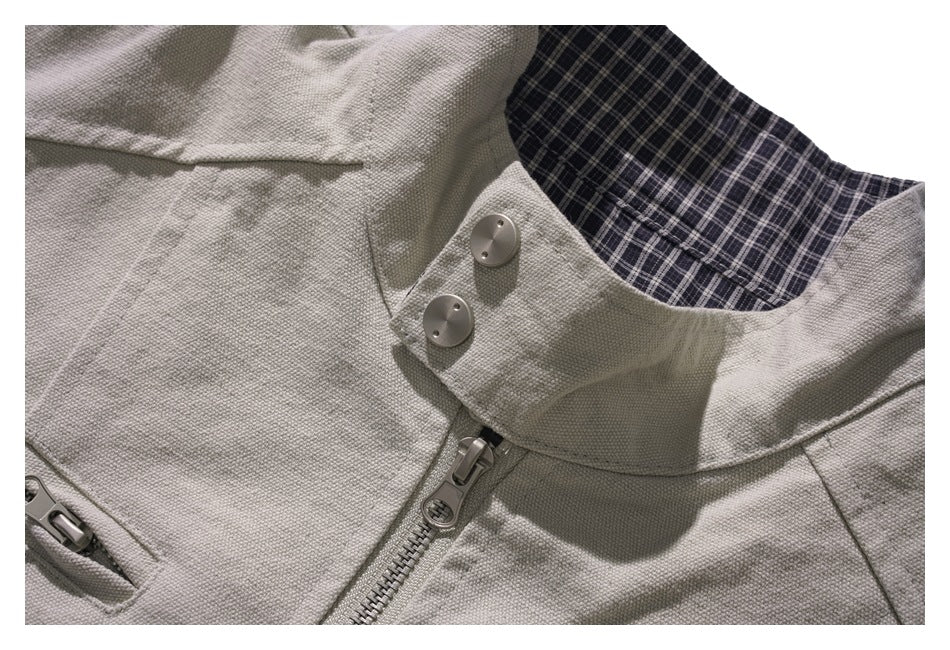 Close-up of the jacket’s plaid-lined collar, two buttons, and front zipper.