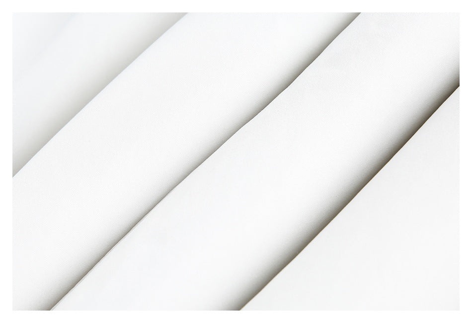 Close-up of smooth white fabric folded into diagonal layers.