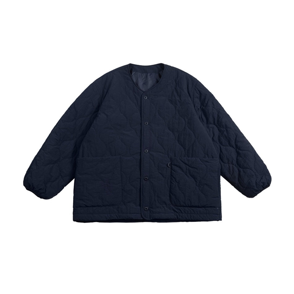 Navy quilted collarless jacket with snap buttons, two large patch pockets and gathered cuffs, flat lay front view