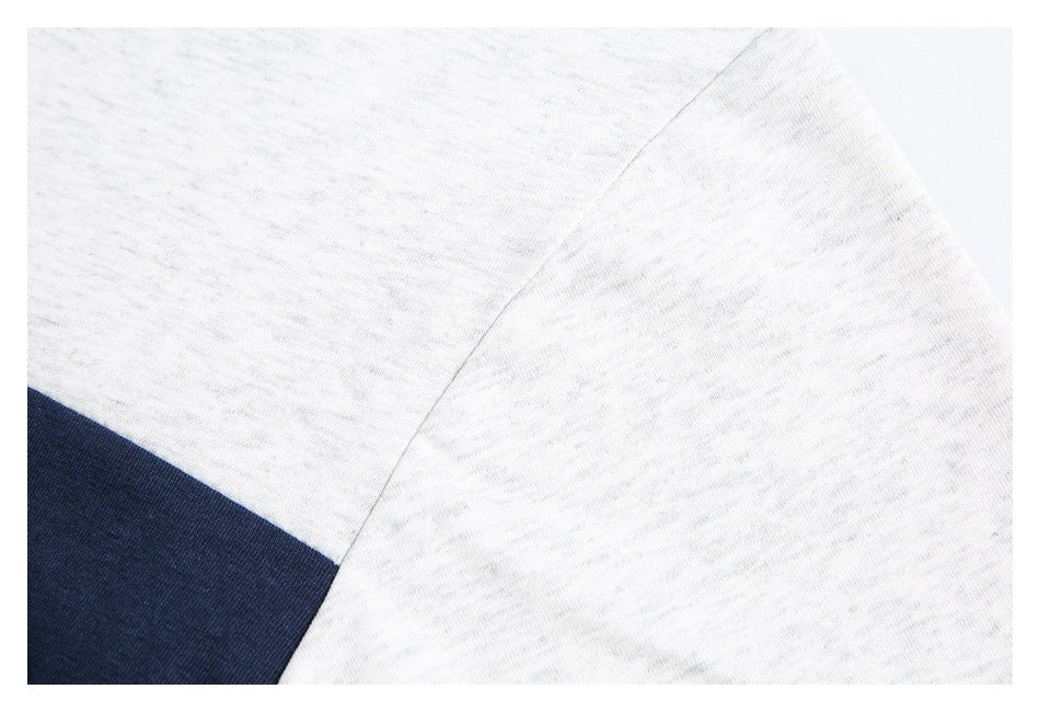 Close-up of a seam joining white heathered fabric panels on a shirt.