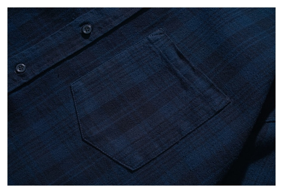 Close-up of a patch pocket and buttons on the dark navy shirt.