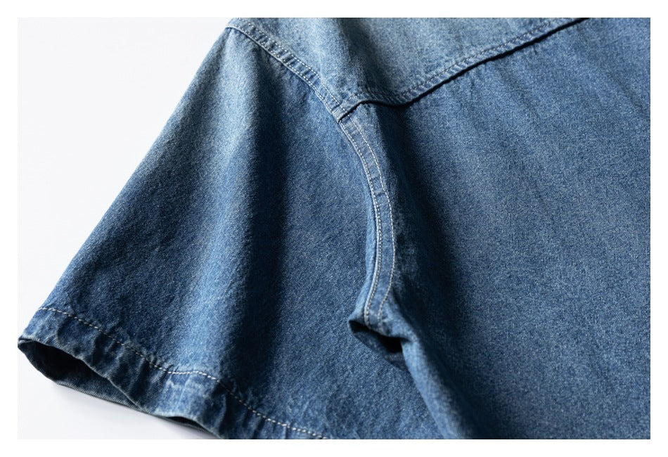 Close-up of a blue denim shirt's short sleeve and shoulder seam.