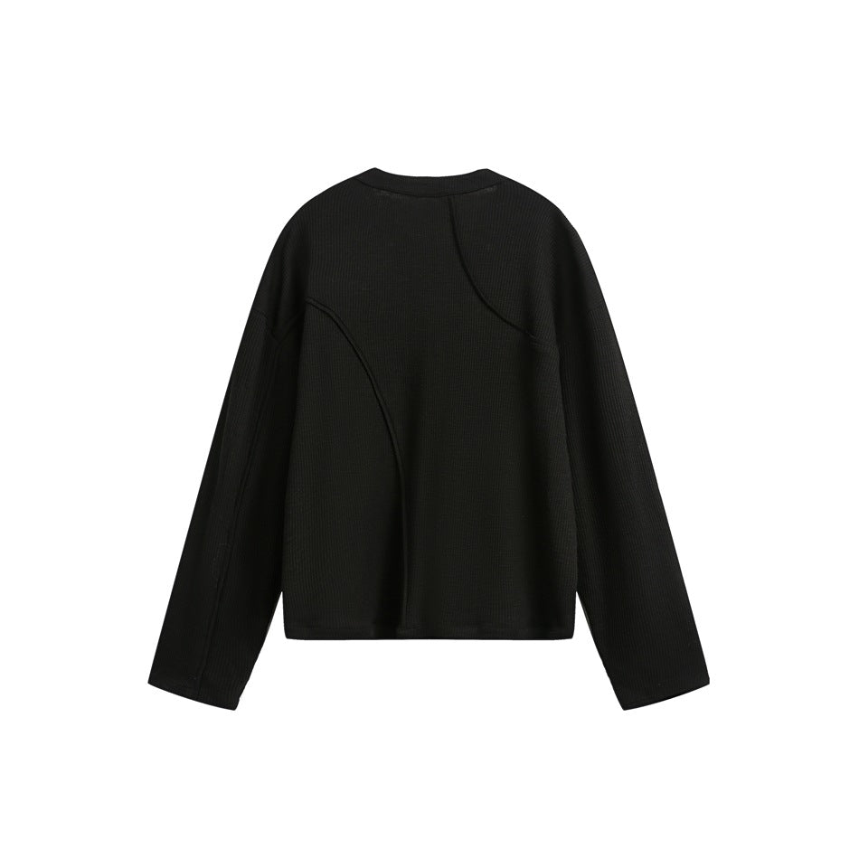 Back view of a black ribbed long-sleeve top with curved seam detailing, shown flat against white.