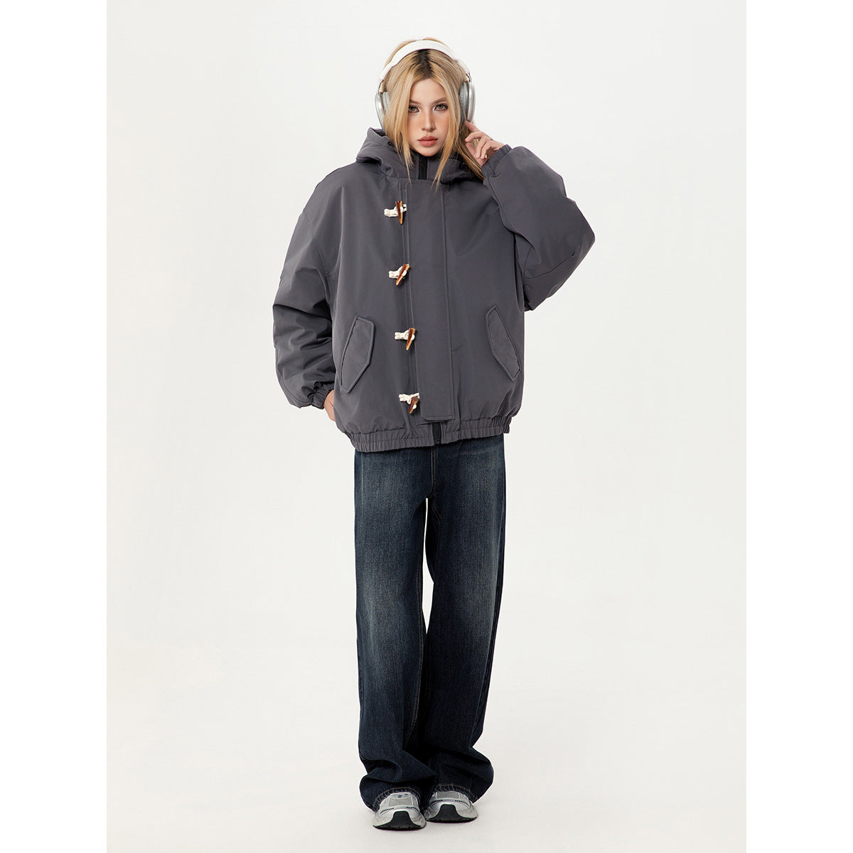 Full-length model wearing a charcoal gray toggle-front hooded jacket with dark wide-leg jeans.