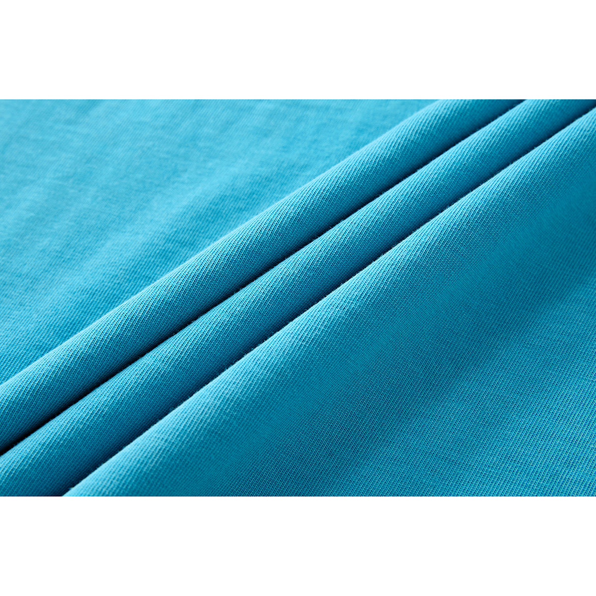Close-up of turquoise fabric arranged in diagonal folds, showing its knit texture.