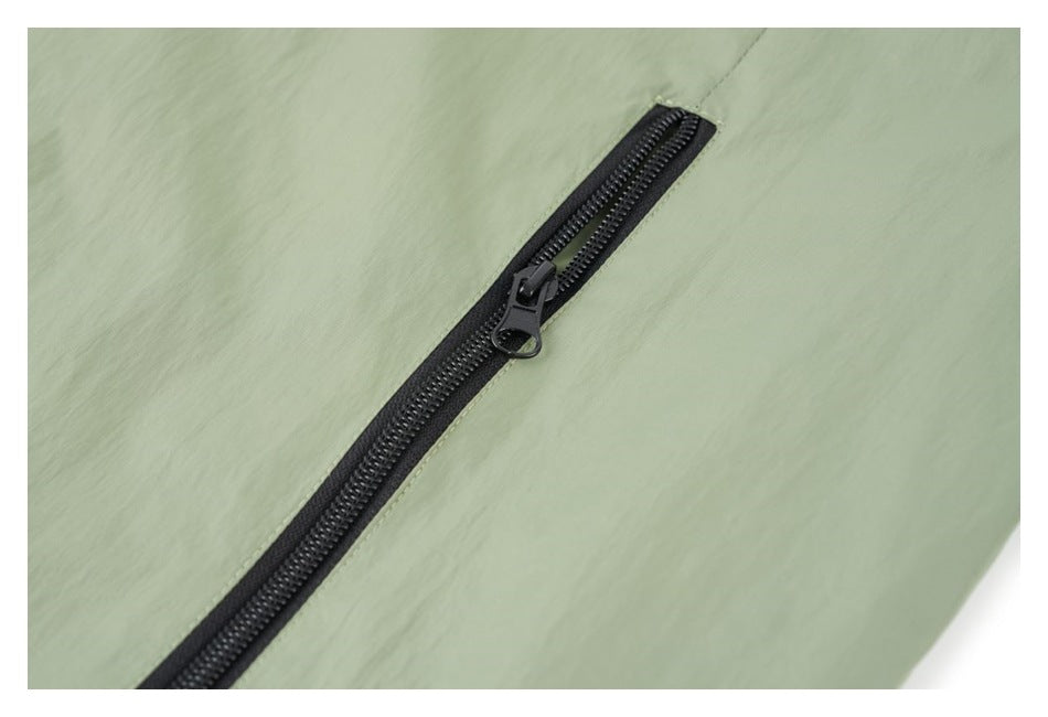 Close-up of a black zipper on the sage green jacket.