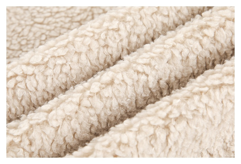 Macro view of the light beige jacket's thick, curly plush texture.
