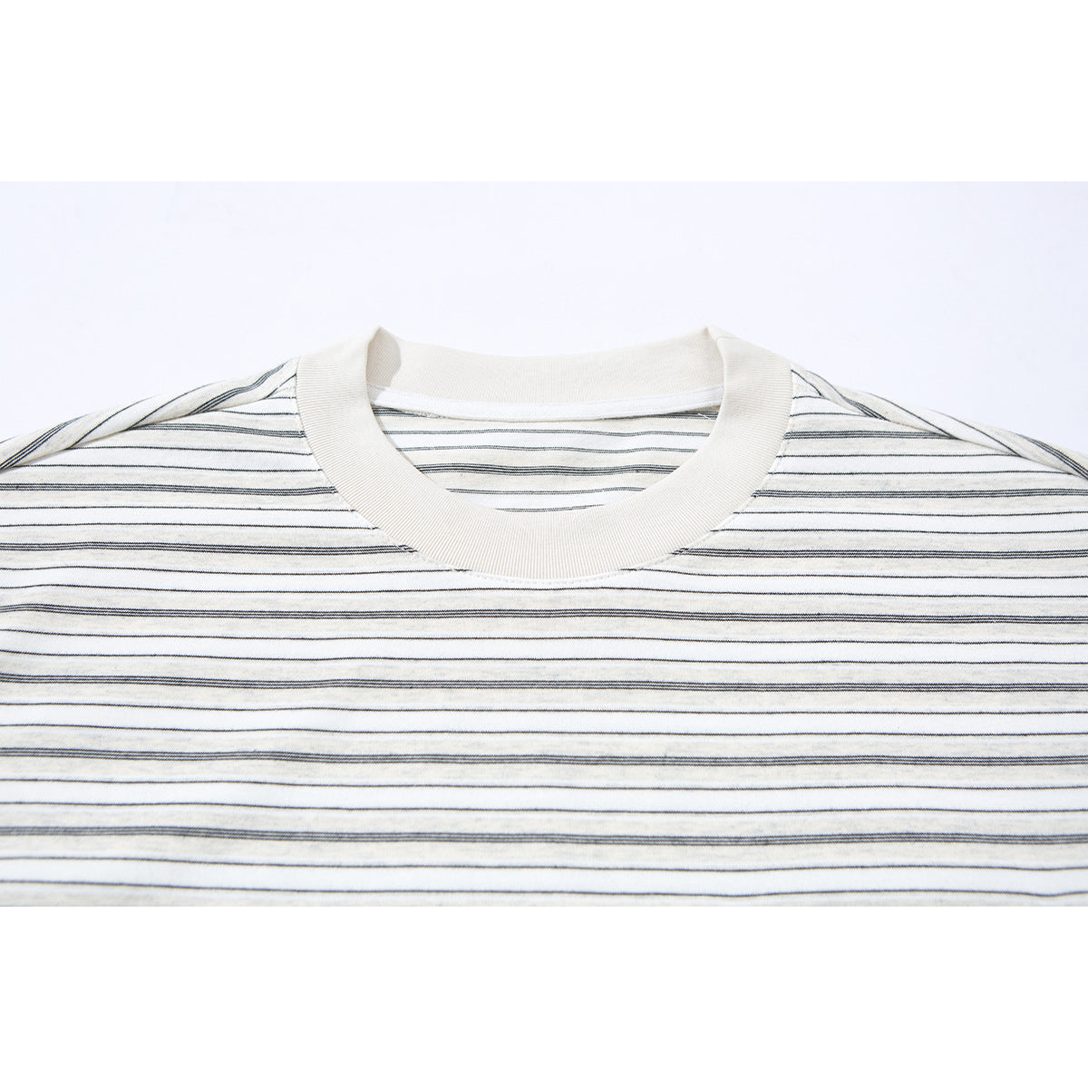 Close-up of an ivory T-shirt's ribbed crew neck and fine dark horizontal stripes.