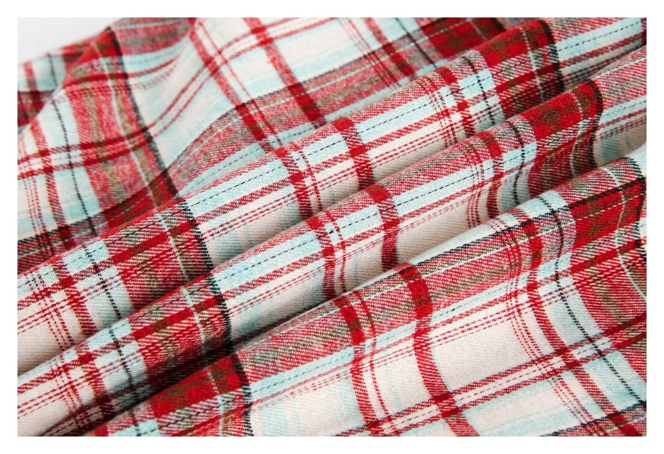 Close-up of red, cream, pale blue, and dark plaid fabric folded to show its weave and pattern.