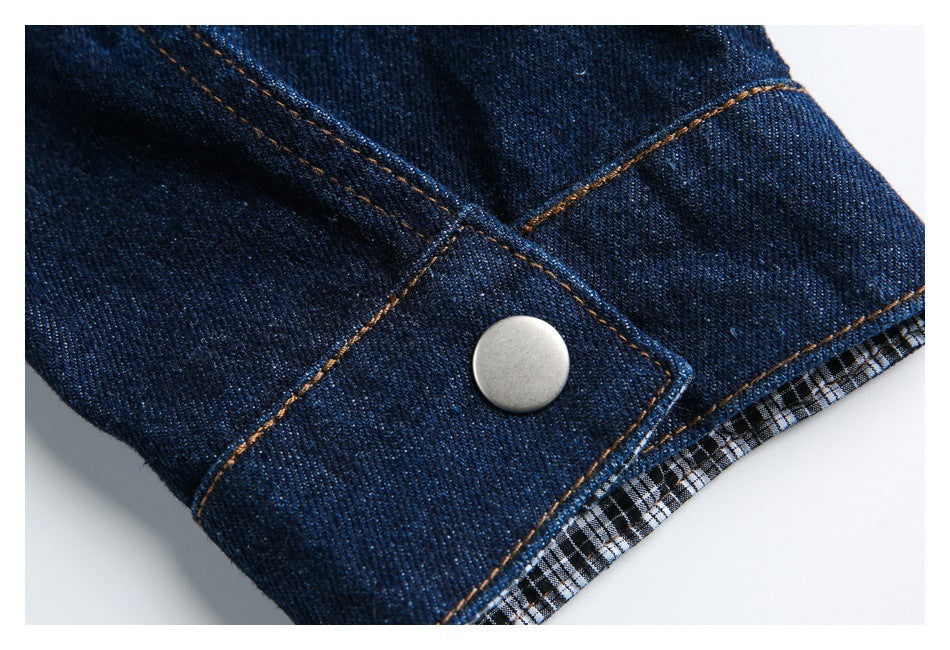 Dark indigo denim cuff with a silver snap and a glimpse of black-and-white check lining.