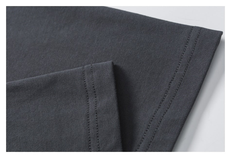Close-up of dark charcoal fabric showing a folded edge and parallel stitching.