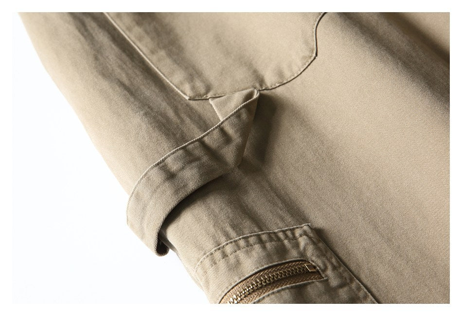 Close-up of khaki trousers showing a folded cuff and small zippered pocket.