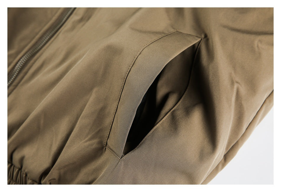 Close-up of a slanted side pocket on tan trousers.