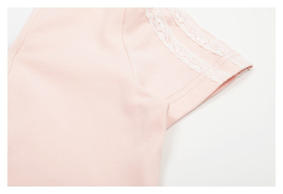 Close-up of pale pink garment fabric with a white lace trim and stitched seam.