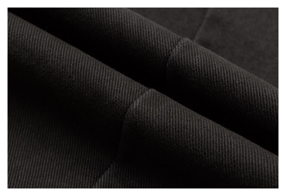 Macro view of dark, finely ribbed fabric folded to show its texture.
