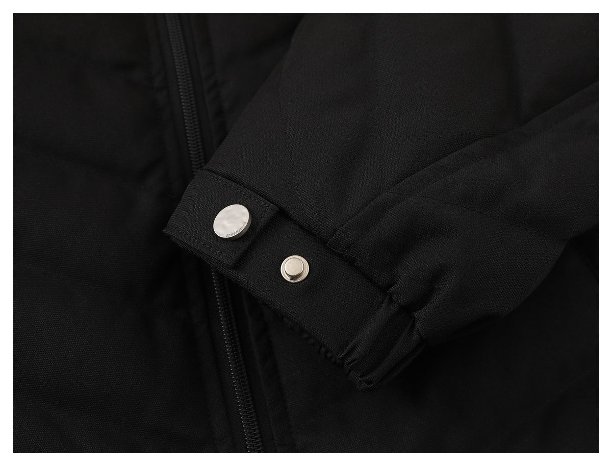 Close-up of a black jacket sleeve cuff with a silver snap fastener.