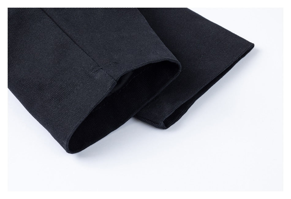 Close-up of the black jacket's sleeve cuff and layered hem.