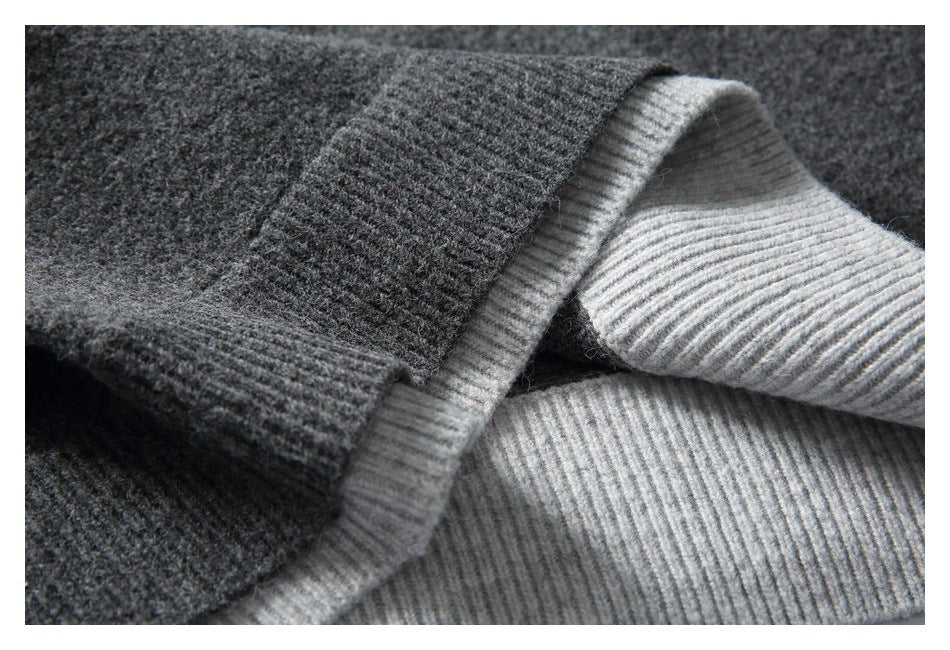 Close-up showing the charcoal sweater's ribbed edge folded back to reveal its light gray underside.
