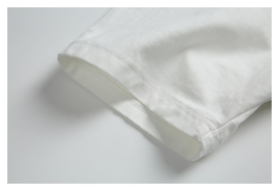 Close-up of the hem stitching on a white T-shirt sleeve.