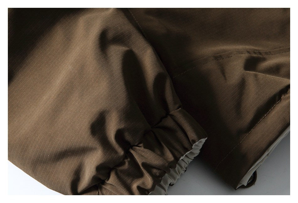 Close-up of a dark brown garment with a gathered cuff and stitched seam.