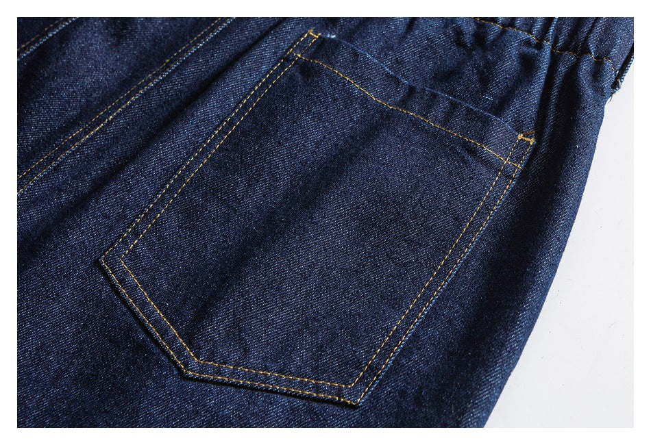 Close-up of a stitched back pocket on dark indigo denim pants.