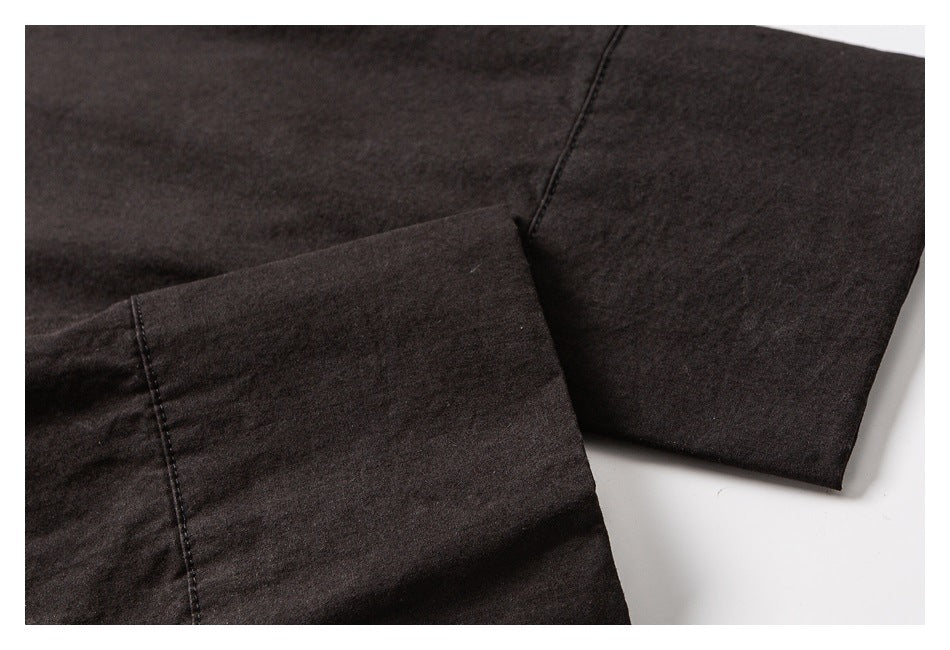 Close-up of a dark garment sleeve and wide cuff with visible stitching.