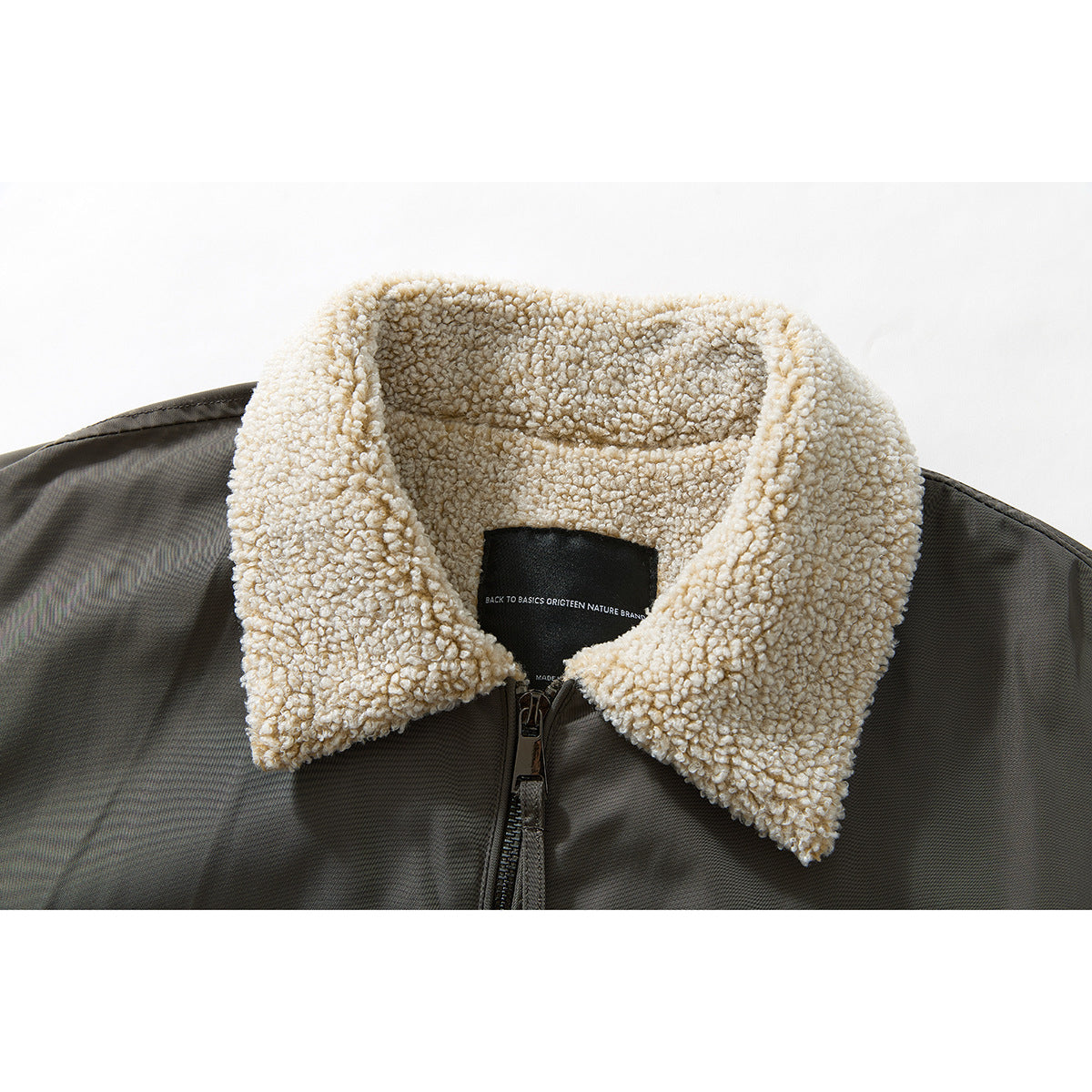 Close-up of a dark olive jacket with a thick cream sherpa collar and center zipper.